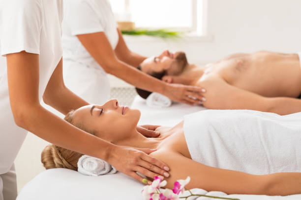 Relaxed Spouses Receiving Shoulders Massage Enjoying And Relaxing During Couples Beauty Therapy At Luxury Spa Center, With Eyes Closed. Body Care, Relaxation And Wellness Concept. Selective Focus
